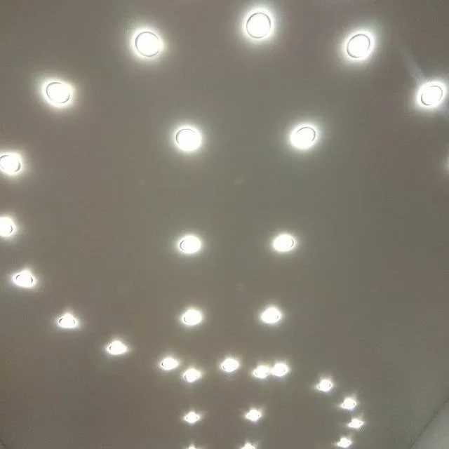 Фото натяжных потолков в зале с люстрой и светильниками - лучшие варианты в интерьере