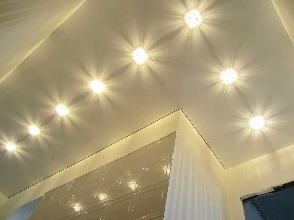 Освещение натяжного потолка в зале (61 фото): как расположить светильники для подсветки в гостиной без люстры? особенности точечного освещения, варианты расположения светодиодных лампочек
